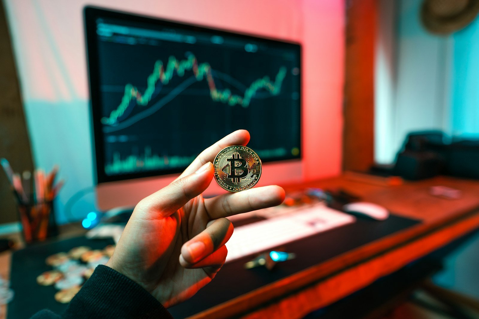 How to Buy Crypto ETNs in the UK: 2026 Guide to Rules, ISAs and Fees 2 Investor holding a coin while reviewing crypto ETNs on a computer